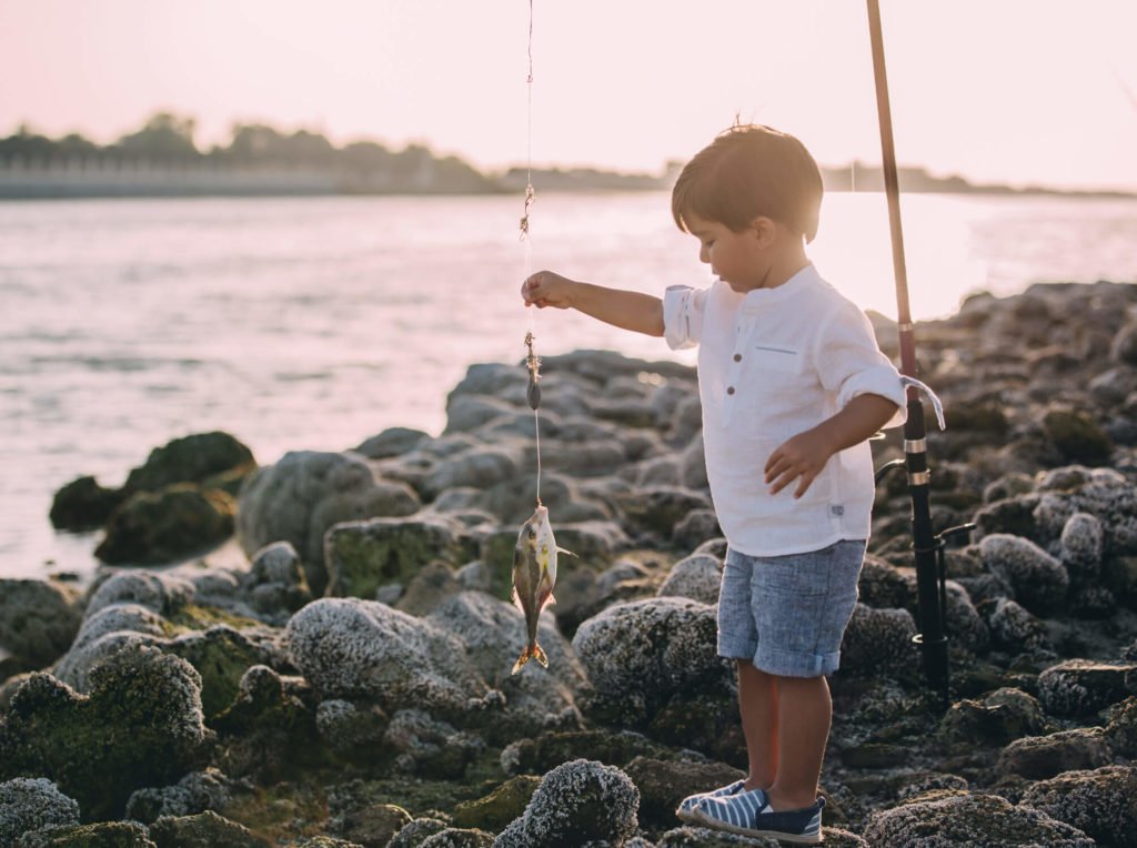 Lifestyle photography: A little boy a fish at the beach in Abu Dhabi