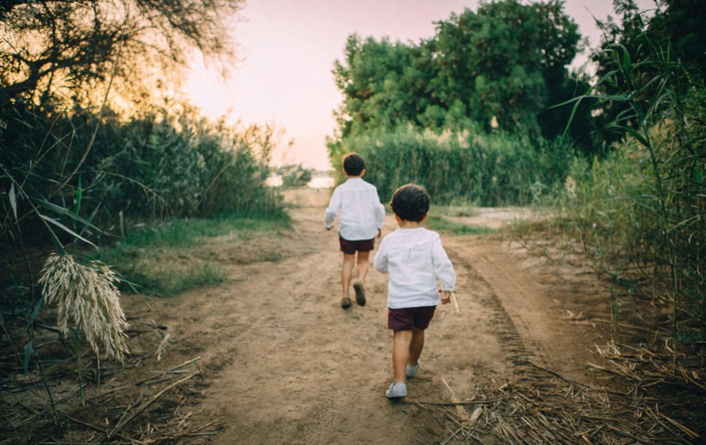Two little siblings run in the park of Abu Dhabi