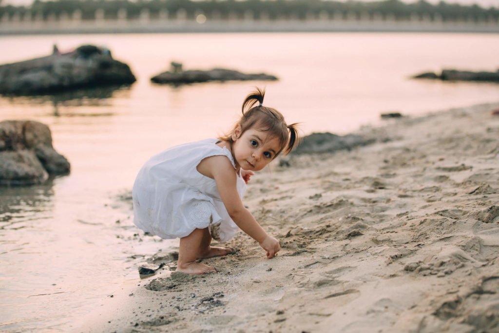 Little girl playing in the beach in Abu Dhabi during sunset
