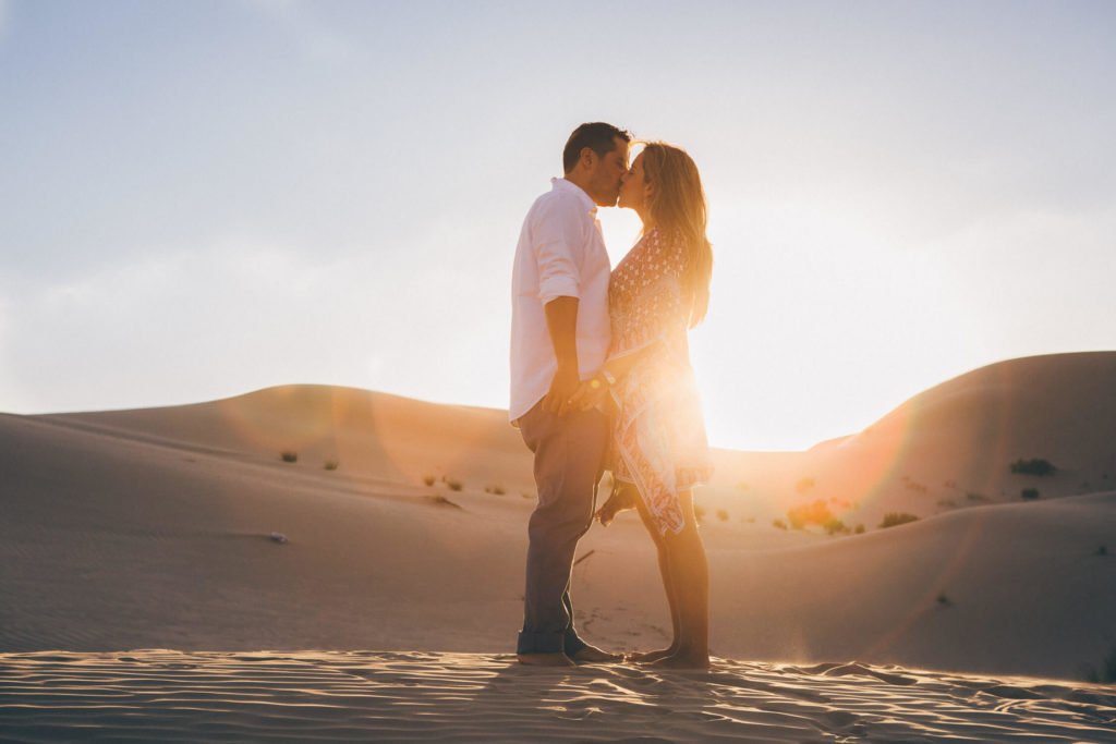 Backlit: Couple kissing in the Abu Dhabi desert dunes