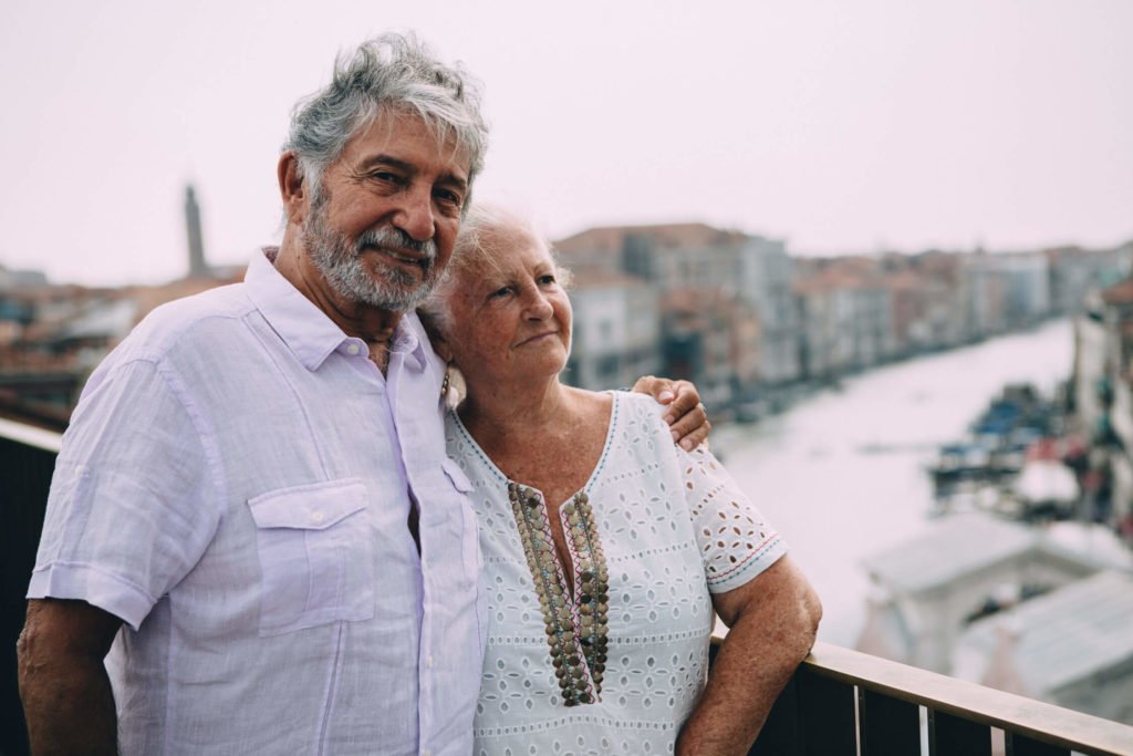 Old cute couple overlooking the canal in Venice
