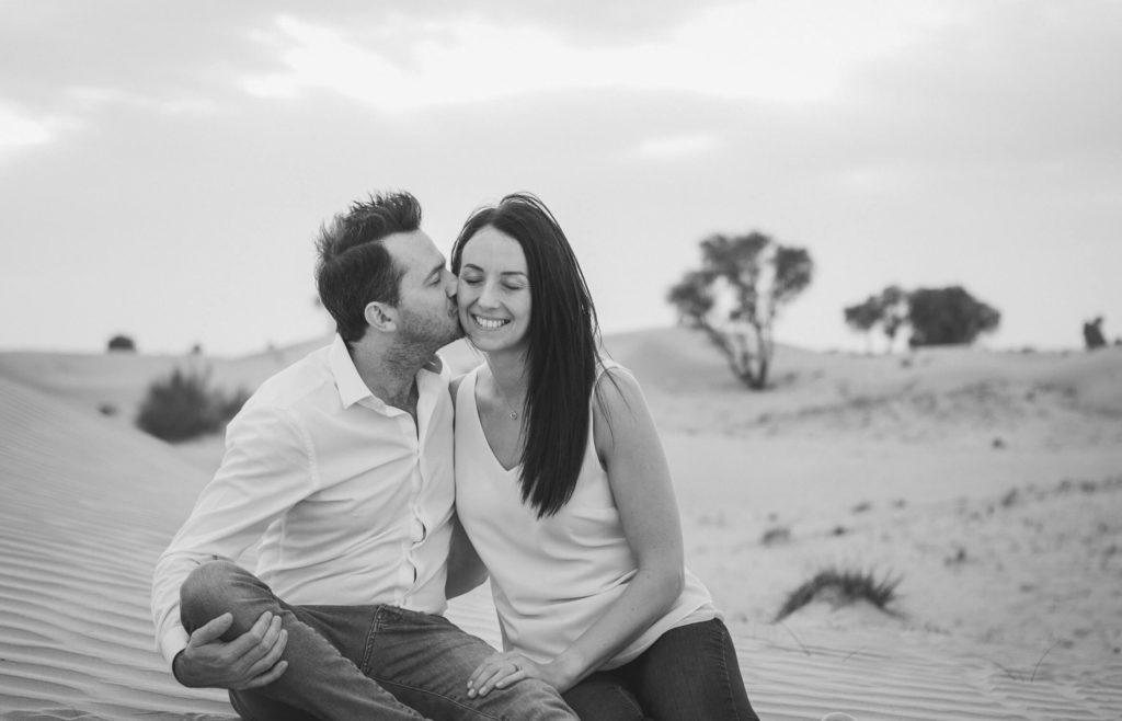A man kisses his wife in Dubai desert