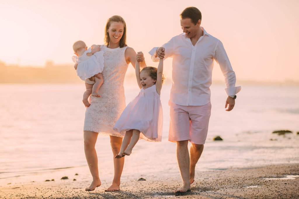 a family playing at the beach during sunset in Abu Dhabi