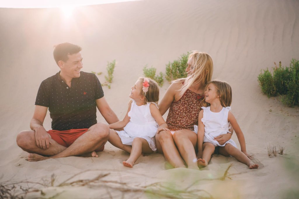 Lightback portrait of a family of four dad, mum and two girls