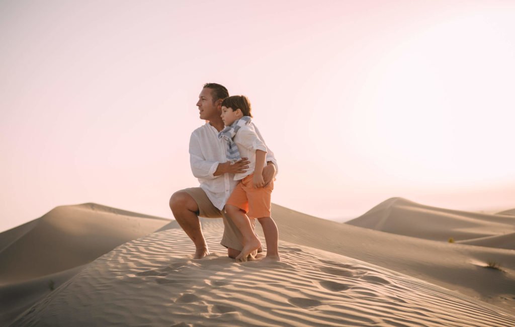 A dad and his boy in the desert dunes of Abu Dhabi