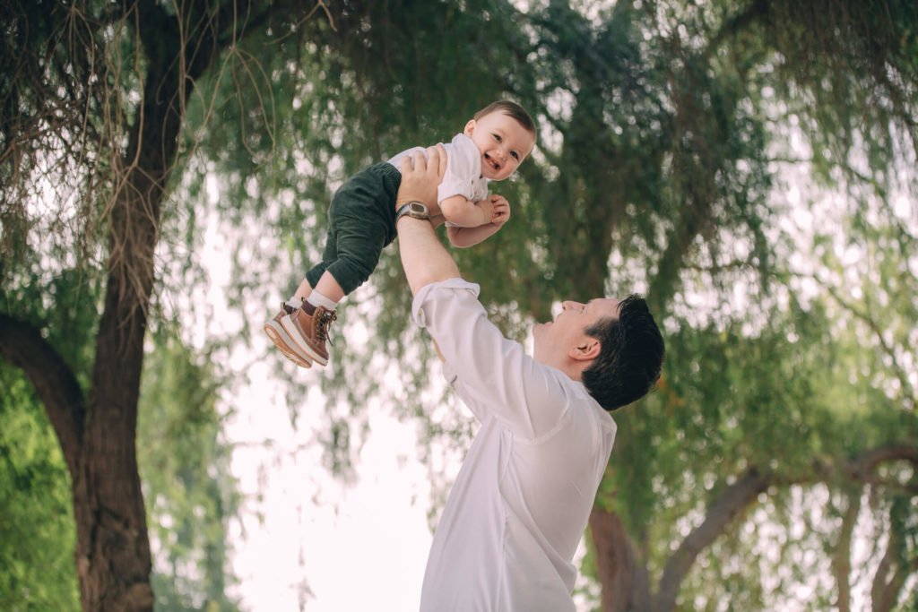 In Dubai a dad holds his baby boy up in the air