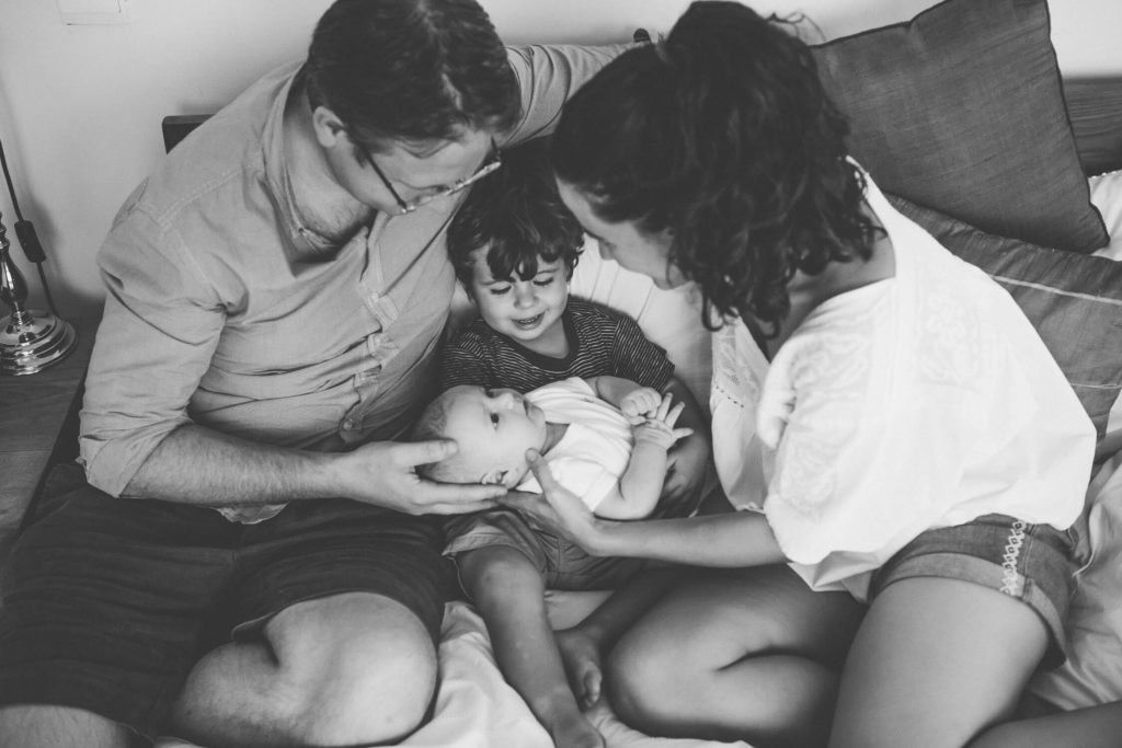 Dad and mum show their toddler his newborn baby brother in Dubai