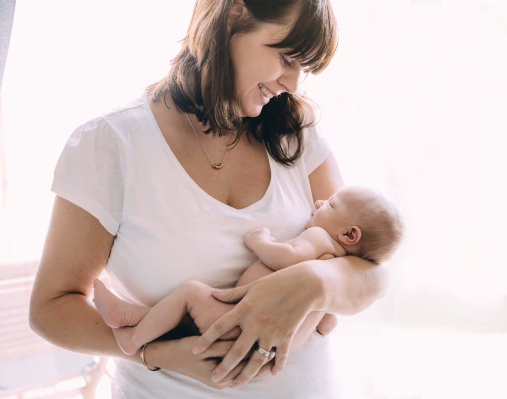 Backlight portrait of a mum looking at her newborn baby