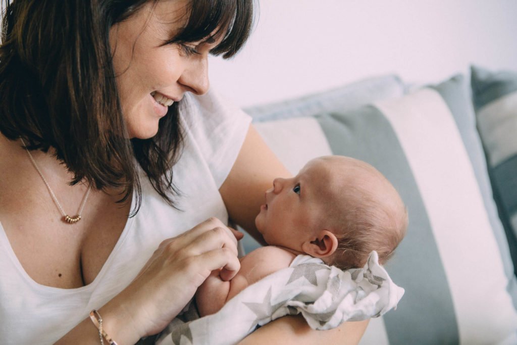 Mum and newborn baby look at each other in love