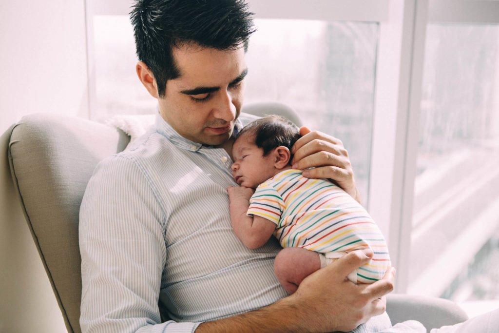 Dad looks carries his newborn