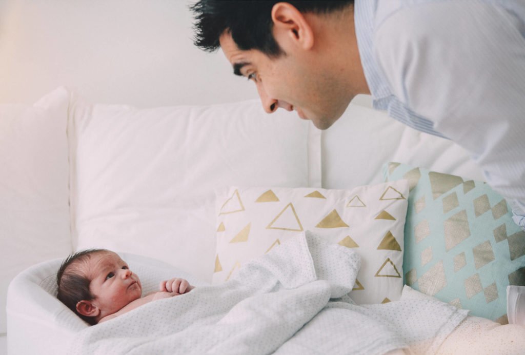 In Dubai a dad is mesmerized looking at his newborn