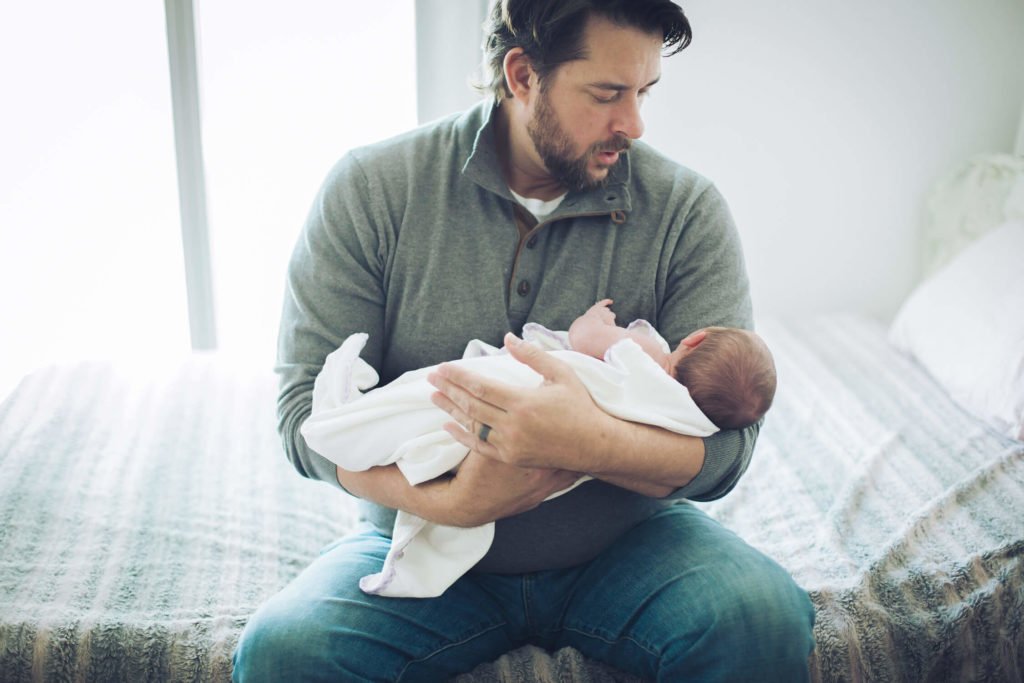 Dad rocking his newborn baby