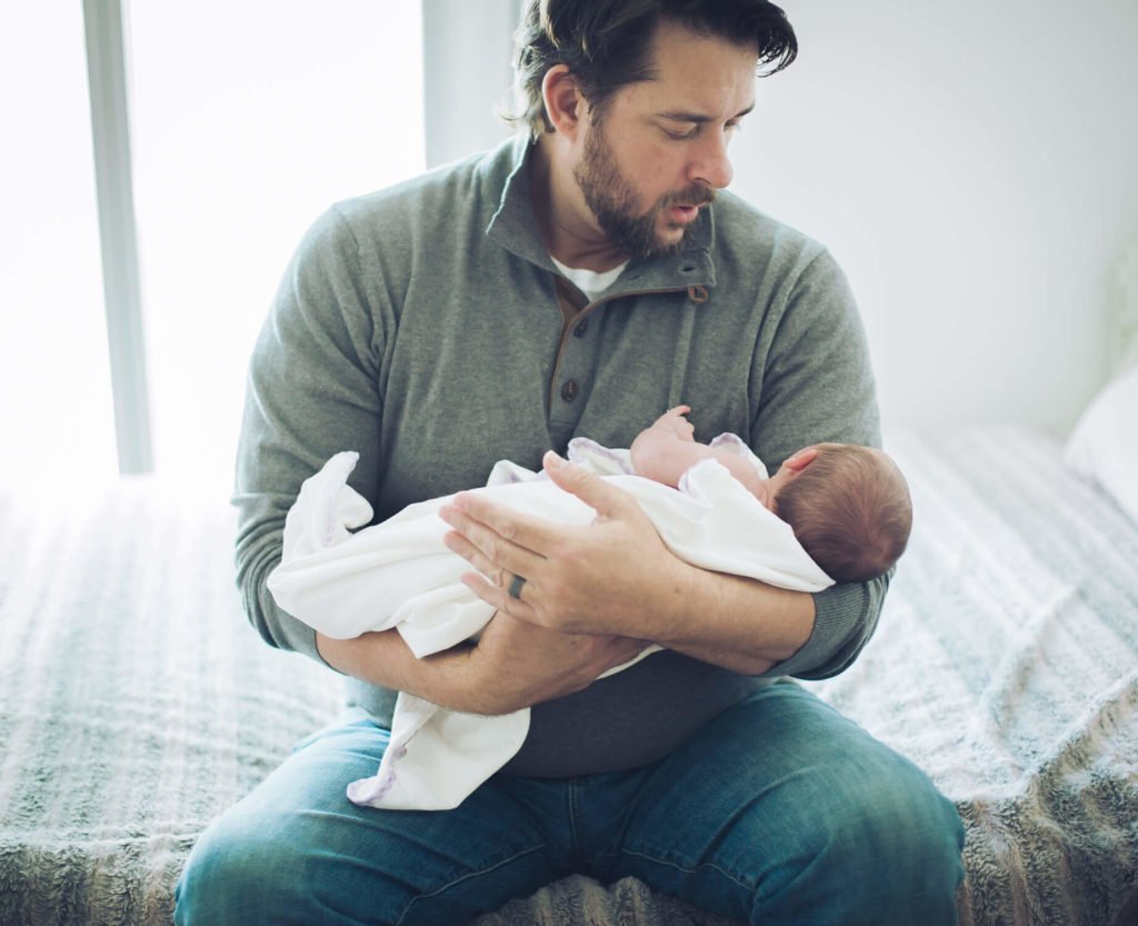 Dad rocking his newborn baby