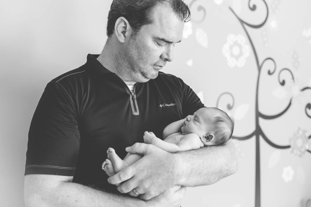 Dad is carrying his tiny newborn girl