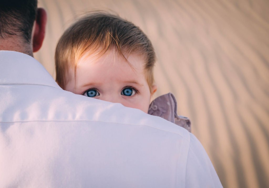Gorgeous blue eyes of a baby girl in the desert of Dubai