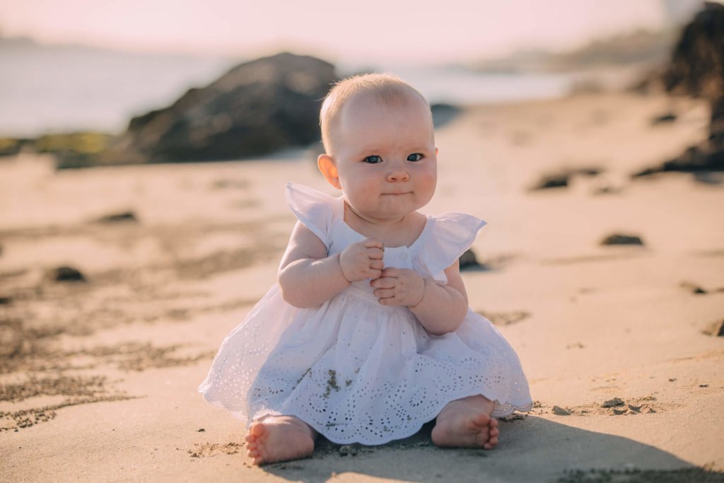 A baby girl sitting in the beach