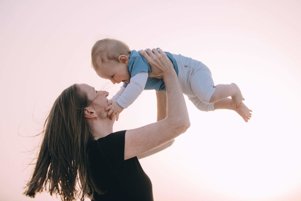 A mum holds up in the air her baby boy