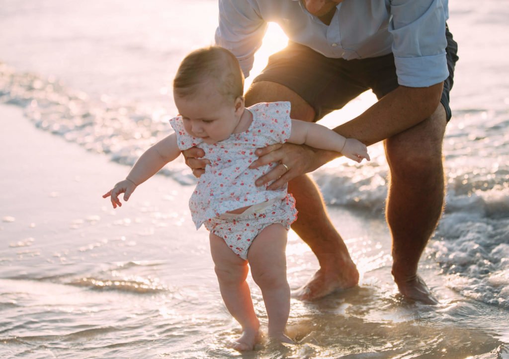 Dad holds his baby girl in the beach of Abu Dhabi during sunset