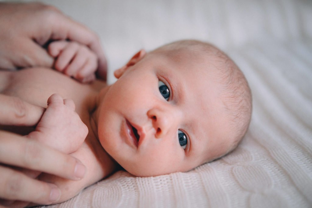 Beautiful newborn portrait with her blue eyes wide open