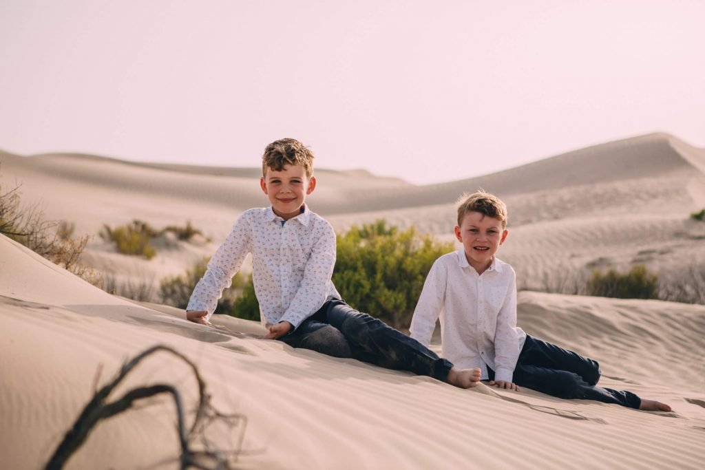 Farewell to the Dubai and Abu Dhabi desert. Two boys sitting in the Dubai sand dunes