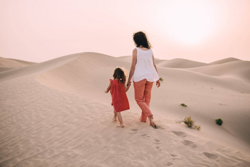 Farewell to the Dubai and Abu Dhabi desert. Mum and her girl walking in the sand dunes of Dubai