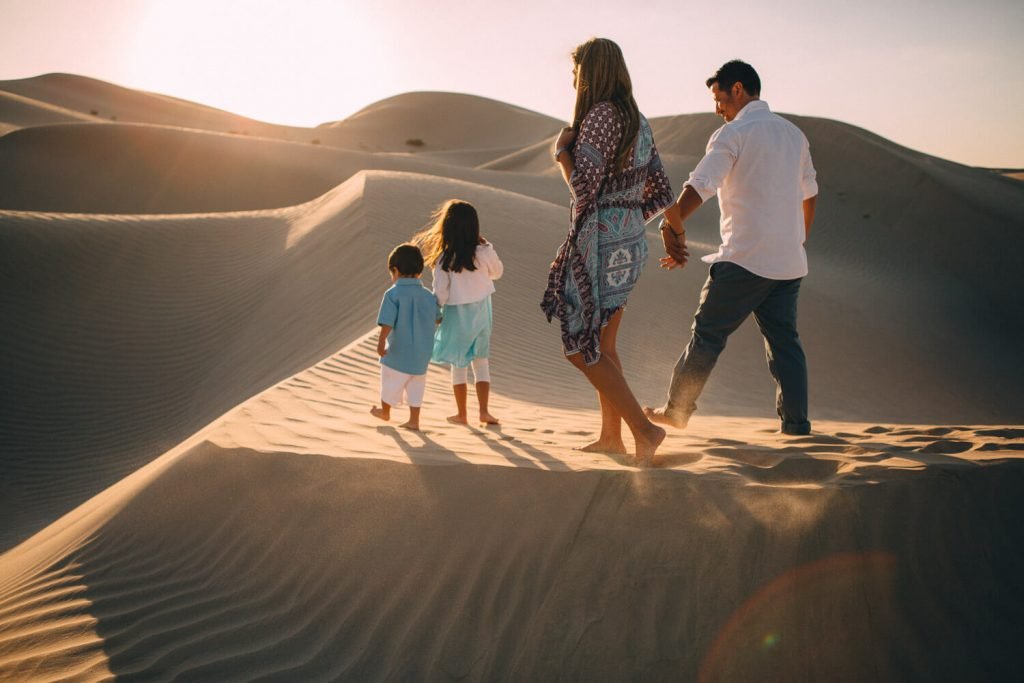 Abu Dhabi desert photo shoot. Family walking in the sand dunes of Abu Dhabi