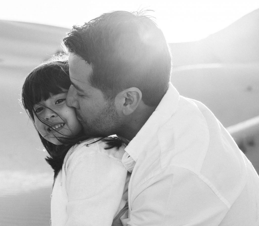 Desert and family photography. Dad kissing his little girl