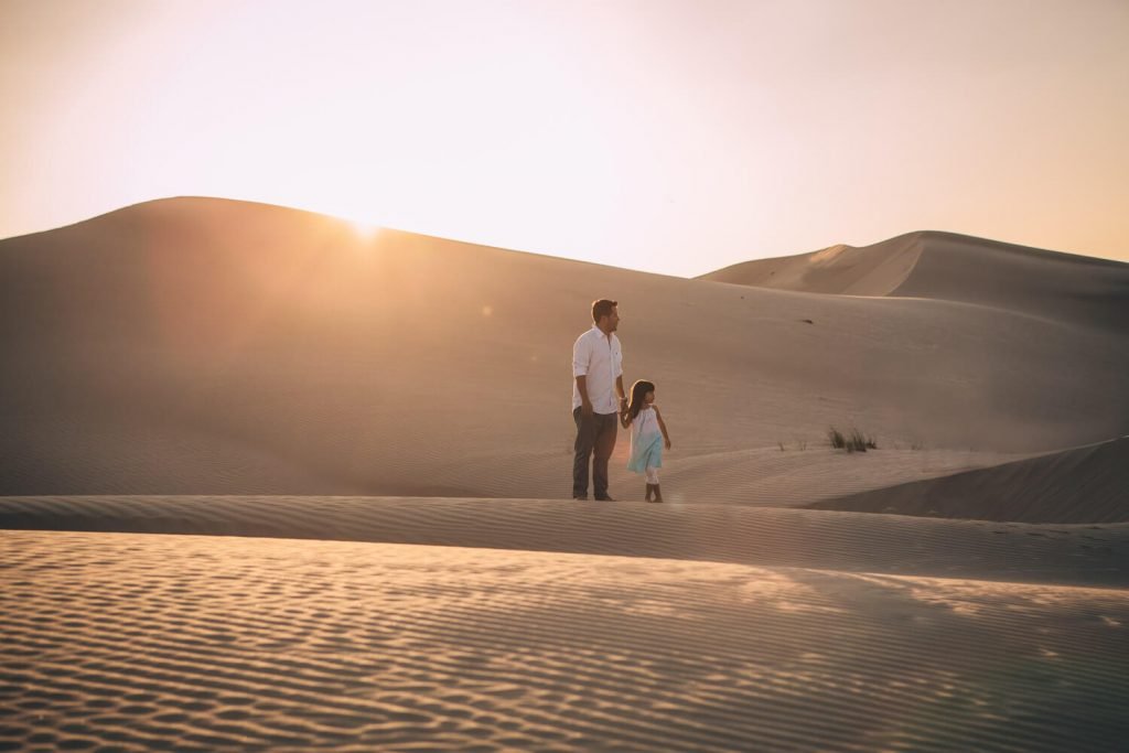 Desert photoshoot in Abu Dhabi. Dad and girl in front of the sand dunes of Abu Dhabi