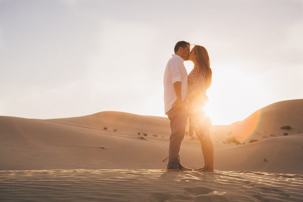 Couple photoshoot in the desert. Couple kissing in the sand dunes of Abu Dhabi