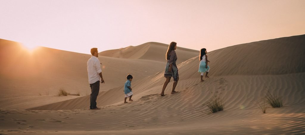Sunset photography in the desert in Abu Dhabi. Family walking in the desert