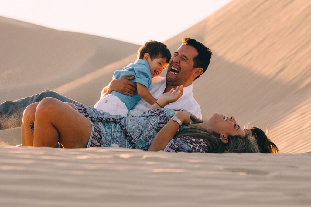 Abu Dhabi family and desert photographer. Family laughing in the sand dunes of Abu Dhabi