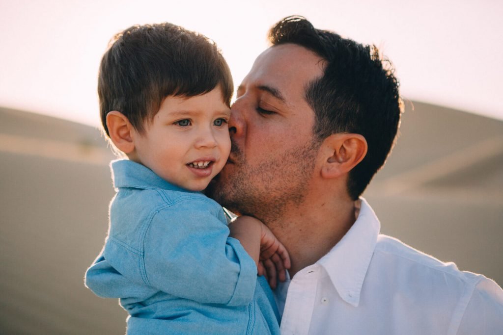 Abu Dhabi family and desert photographer. Dad kissing his little boy