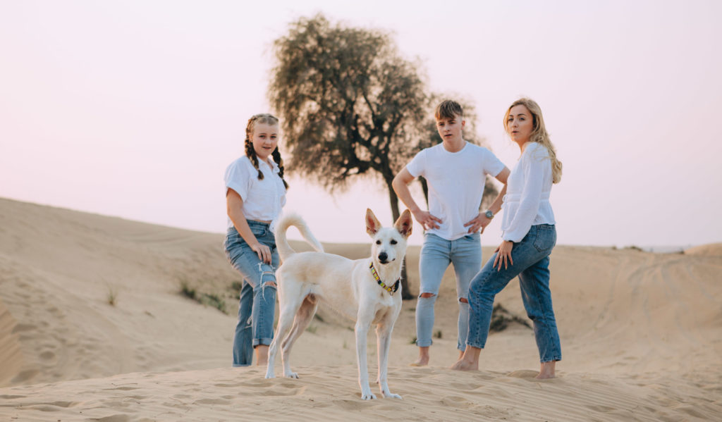Teenagers and their dog in the desert of Dubai